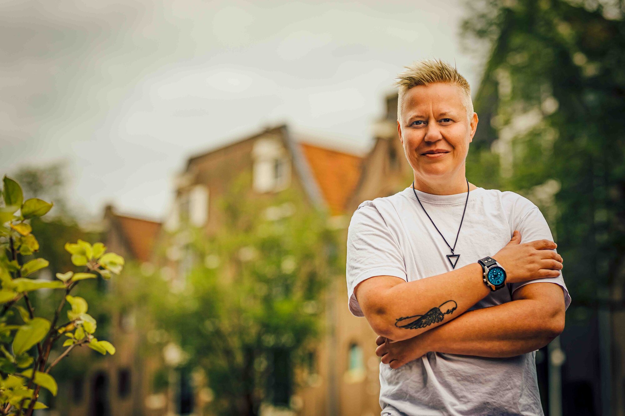 Riley Coleman standing with arms crossed among Amsterdam canal houses